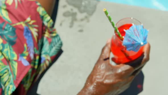 Close-upof bllack man drinking cocktail drink near swimming pool 4k