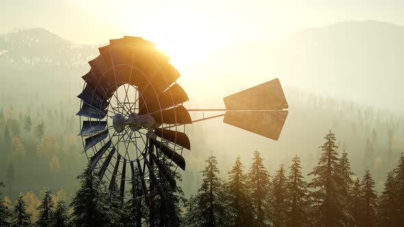 Typical Old Windmill Turbine in Forest at Sunset