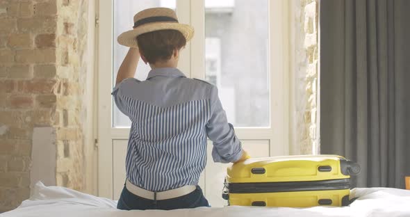 Gorgeous Elegant Caucasian Woman Taking Yellow Travel Bag and Leaving Hotel Room or Bedroom. Smiling