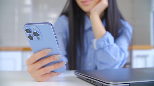 Young girl messaging online with smartphone. Asian woman browsing social media app on phone
