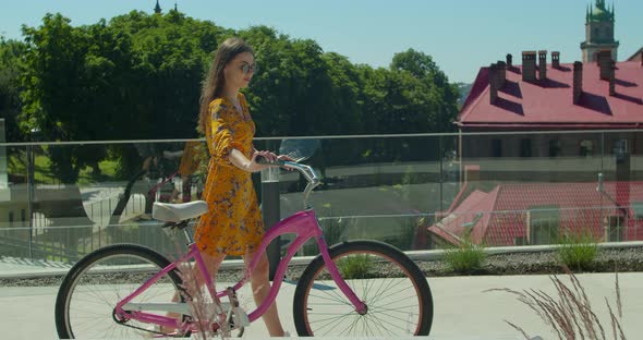 Young Beautiful Woman Riding a Bicycle at Sunset. Cyclist Woman Have Fun.