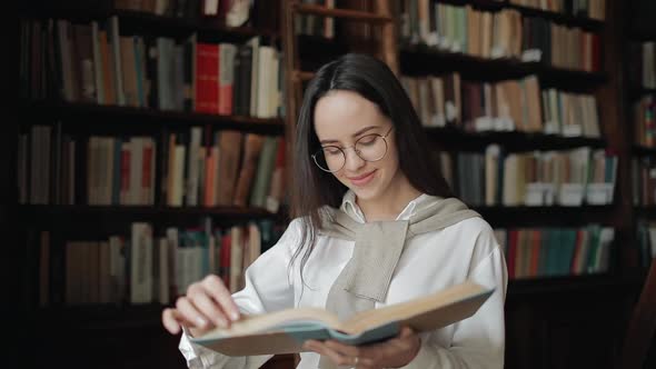 Close Up of Smiling Girl Reading Book