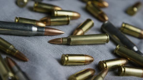 Cinematic rotating shot of bullets on a fabric surface - BULLETS 098