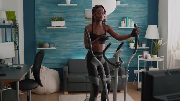 Cyclist Woman with Black Skin in Sportswear Training Body Muscle Using Elliptical