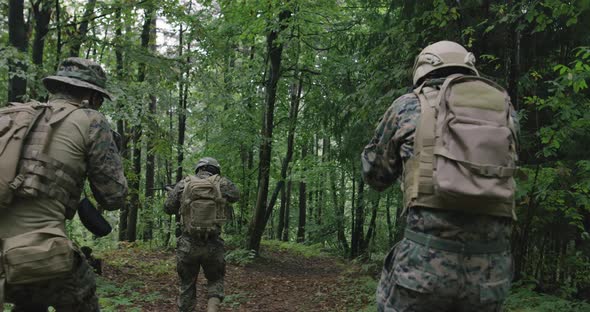 Soldiers Moving Through Forest During Tactical Action Concept of War and Attacking