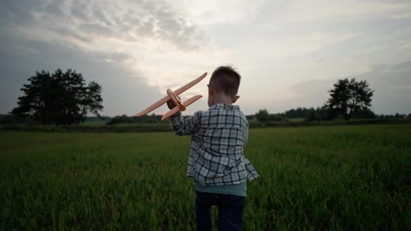 A Child Travels Holding an Airplane in His Hands