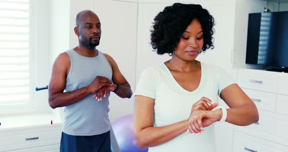 Couple using smartwatch while exercising together 4k