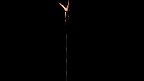 Dancer in Underwear Spinning on a Pole . Black Background. Silhouette