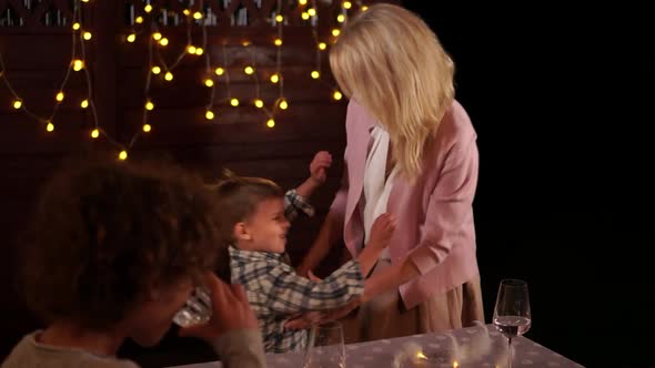 Happy Family, Husband and Wife and Two Children Set the Table on Christmas Evening with Festive