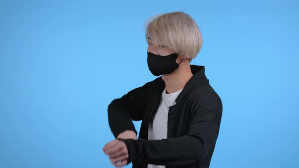 Young Asian Man in Protective Mask Dancing on Blue Studio Background