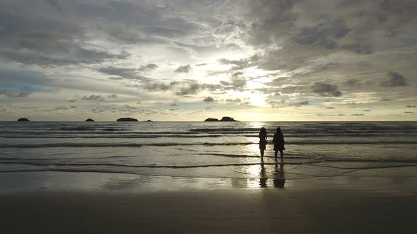 Aerial view of two womans taking photos of the sunset, Ko Chang, Thailand.