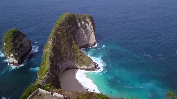 Amazing aerial view flight fly forwards drone shot slowly tilt down Kelingking Beach at Nusa Penida