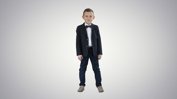 Smiling little boy in formal clothes standing on gradient