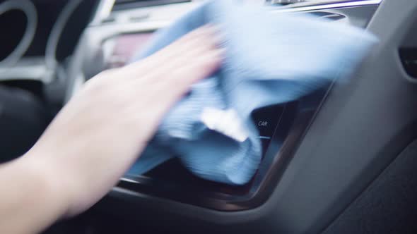 A Man Wipes the Car Radio Display with a Cloth - Closeup