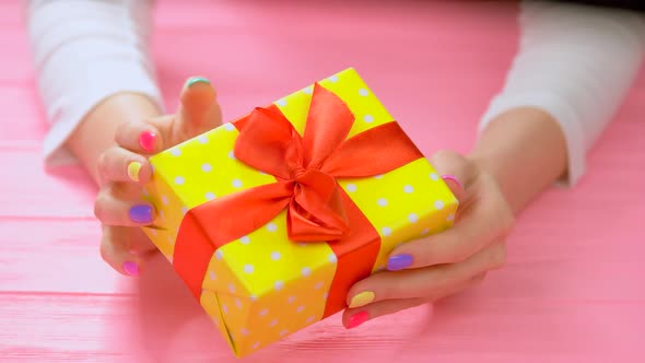 Yellow Gift Box in Female Hands.