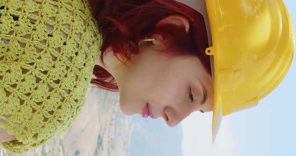 Portrait of a girl engineer looking at the panorama in the mountains