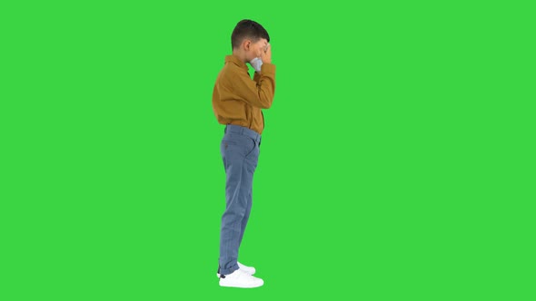 Little Boy Taking His Face Mask Off and Smiling at Camera on a Green Screen, Chroma Key