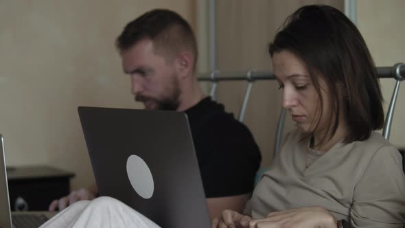 Couple On Bed Using Laptop Computers