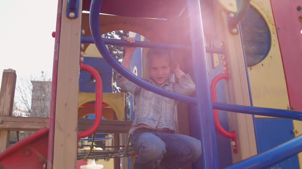 Joyful Junior Schoolgirl Poses on Attraction with Blue Tubes