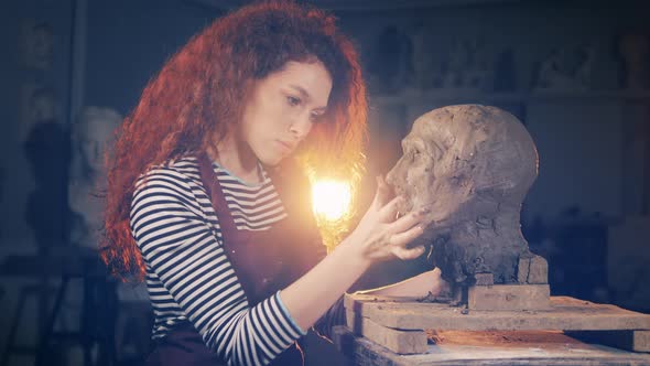 Female Sculptor is Making a Head From Clay