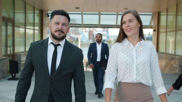 Slow Motion Dolly Shot Portrait of Cheerful Man and Woman Colleagues Walking Outdoors Near Office