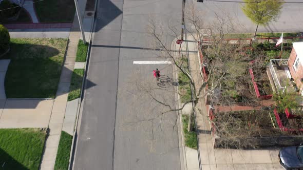 An aerial shot taken over a suburban neighborhood on a sunny day. The drone camera looking down doll