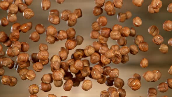 Super Slow Motion Shot of Flying Hazelnuts After Being Exploded on Wooden Background at 1000 Fps.