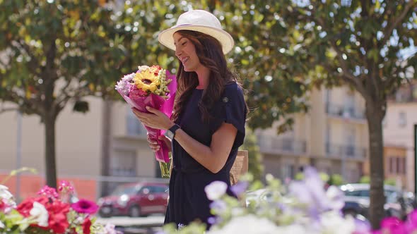 Smiling woman holding fresh bunch of flowers