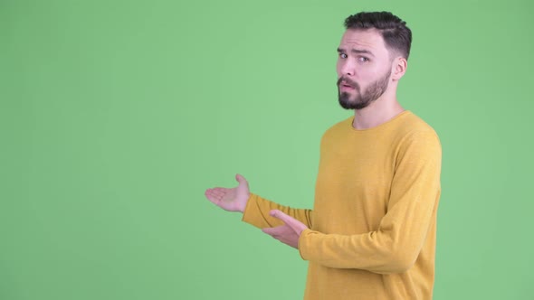 Stressed Young Bearded Man Showing To the Back