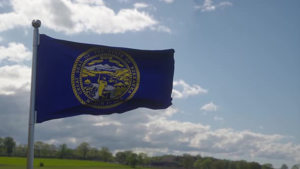 Flag of Nebraska State Region of the United States Waving at Wind