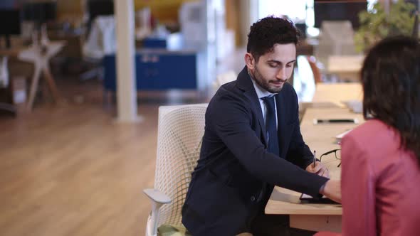 Businessman showing client in office where to sign contract