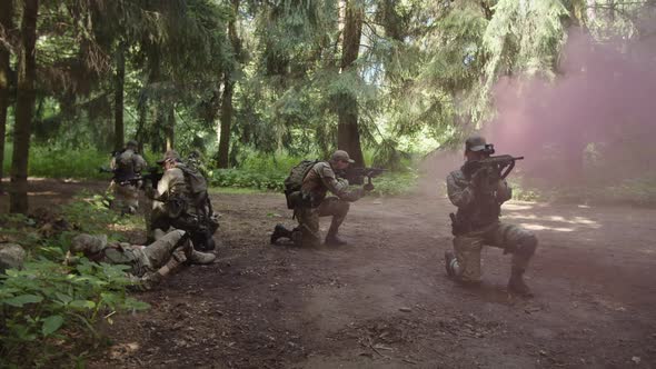 Group of Soldiers Waiting for Military Evacuation Transport in Forest alt