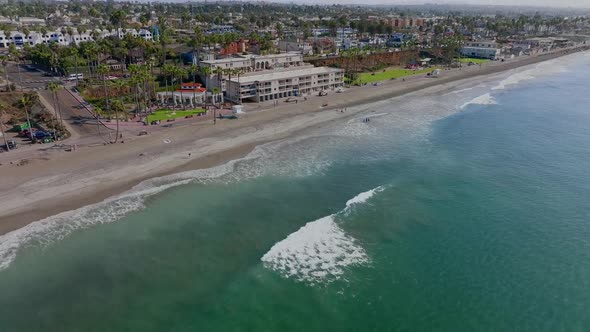 turquoise sea and cityscape of the coastal city of Oceanside, CA, USA. aerial tilt up