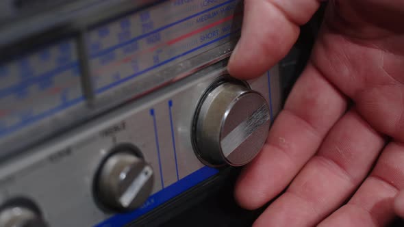 A Hand Turns the Frequency Knob on an Old Gray Tape Recorder  Closeup