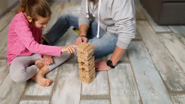 Smiling Little Girl Play with Her Father Constructor of Wooden Blocks at Home