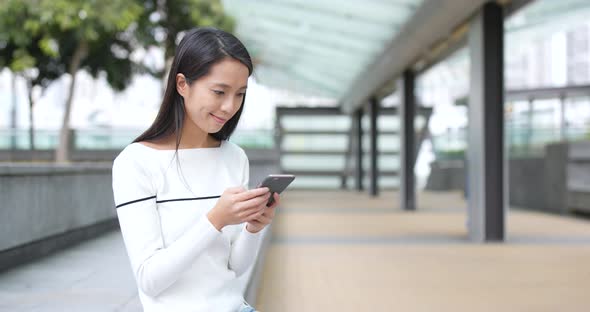 Young Woman look at mobile phone at outdoor