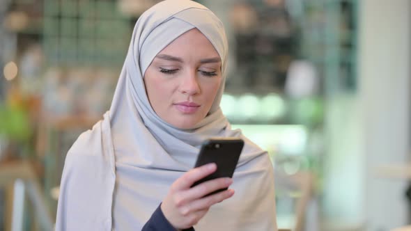 Portrait of Focused Young Arab Woman Using Smartphone 