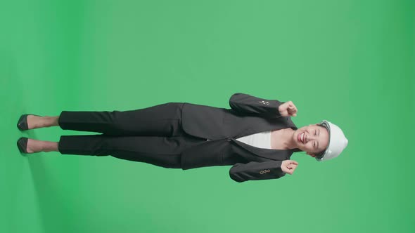 Full Body Of Smiling Asian Female Engineer With Safety Helmet Dancing In The Green Screen Studio