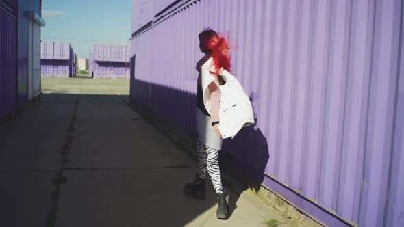 Happy Young Funky Woman with Pink Hair Dancing on Coloured Background