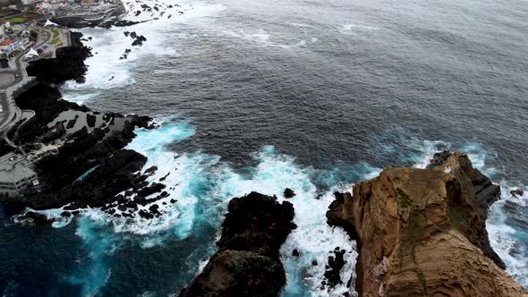 Drone Circle Around Ilheu Mole Cliff Unveiling Porto Moniz Town, Madeira Island, Portugal