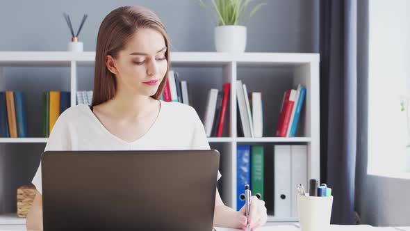 Young Woman Works at Home Office Using Computer.