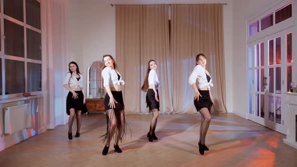 Four Girls in Black Skirts and White Shirts are Dancing Indoors