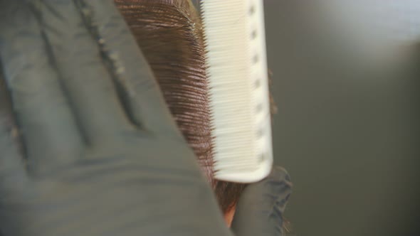 Barber Brushing Client's Wet Hair in Sections