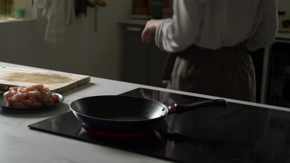 woman roasts a chicken in a frying pan