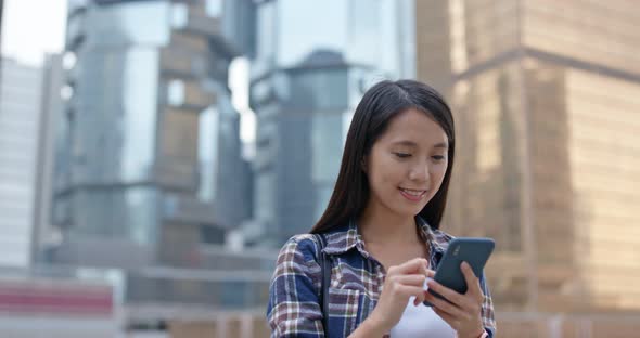 Woman check on mobile phone in city at night