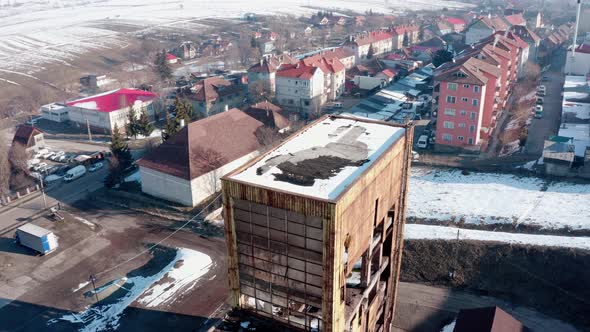 Abandoned industrial building in residential neighborhood, aerial establishing shot