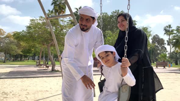 Emirati Family spending during the day. Arab Father with his Middle Eastern Wife and Son wearing Kan