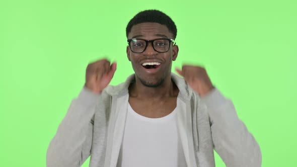 Successful African Man Celebrating on Green Background