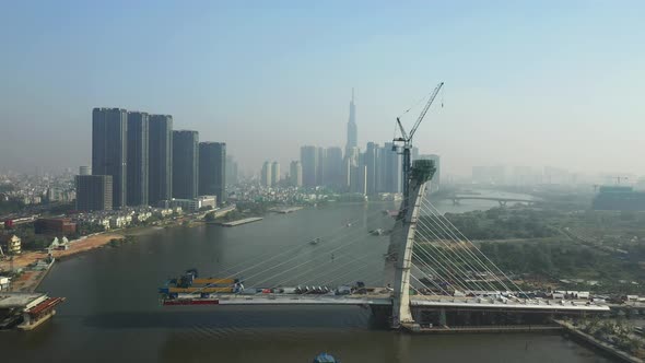 Drone view of Saigon River, Ho Chi Minh City and new Thu Thiem Bridge under construction on a sunny