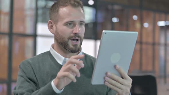 Portrait Shoot of Cheerful Man Celebrating and Using Tablet